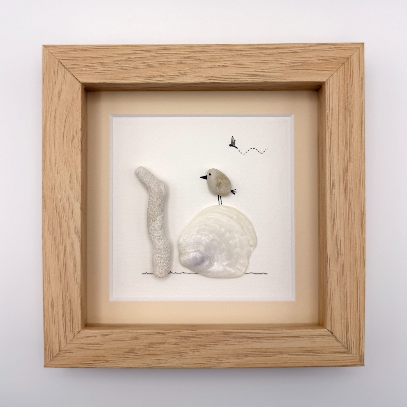 Pebble bird on a white clam shell
