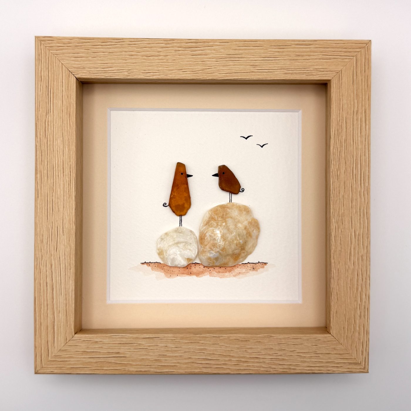 Two amber sea glass birds on shells