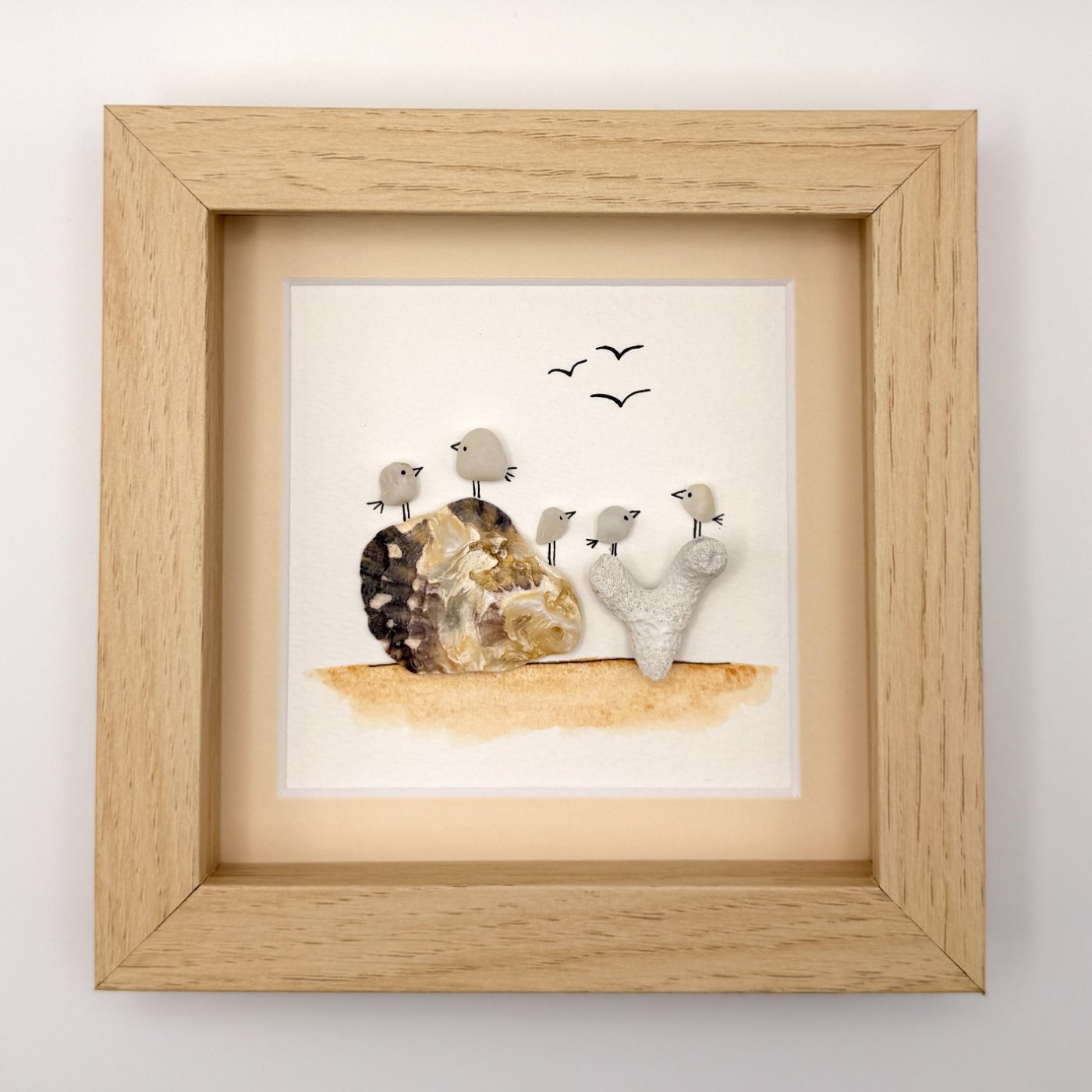 Five sea glass birds on shell and coral