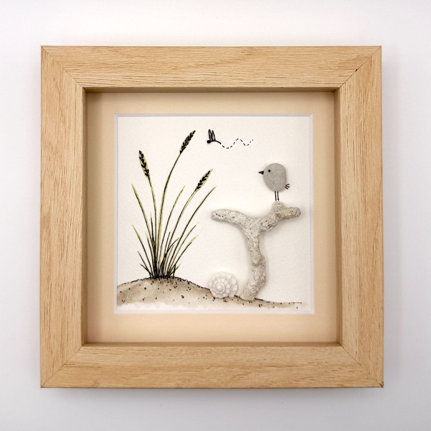 Pebble bird on coral beside dune grass