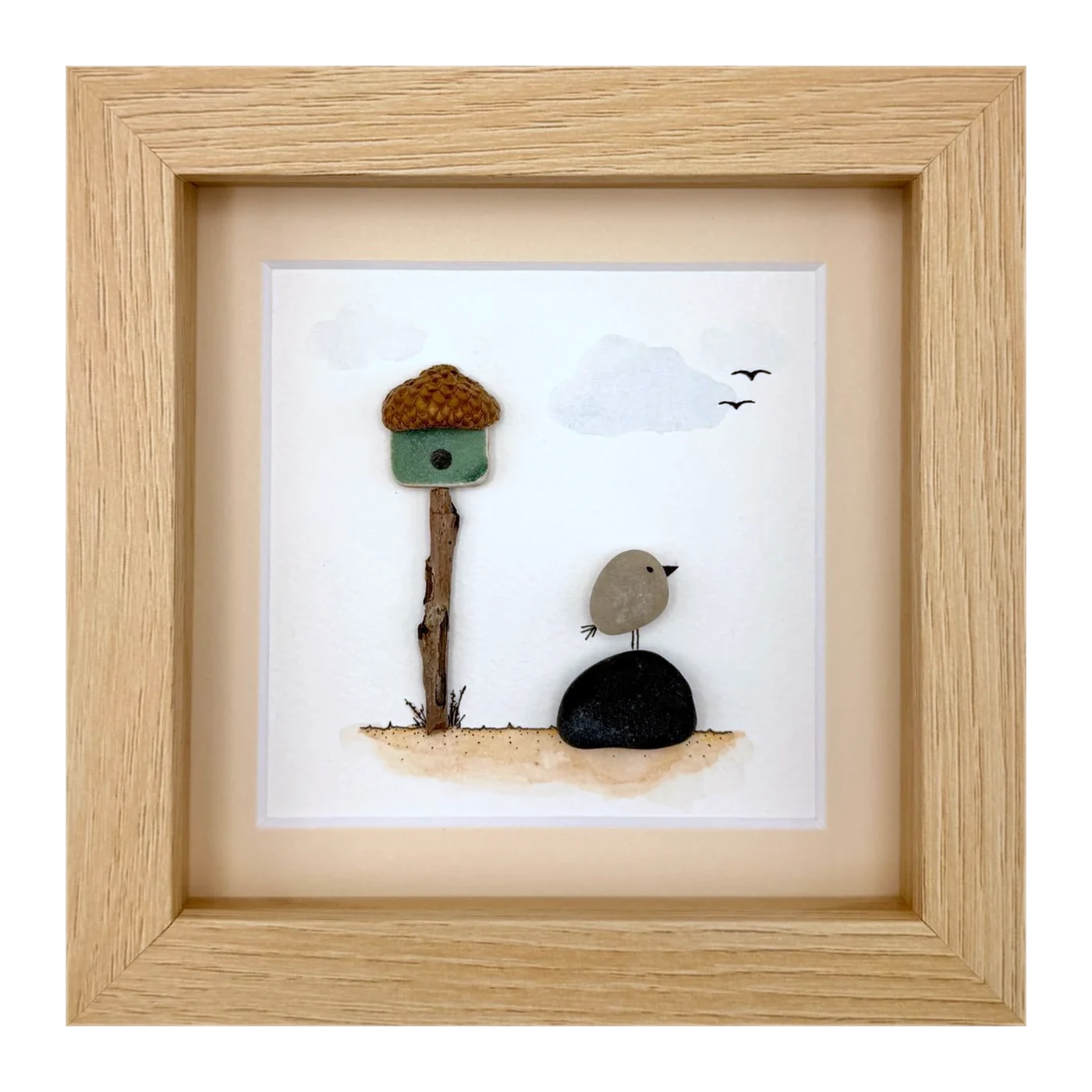 A pebble bird beside an acorn birdhouse
