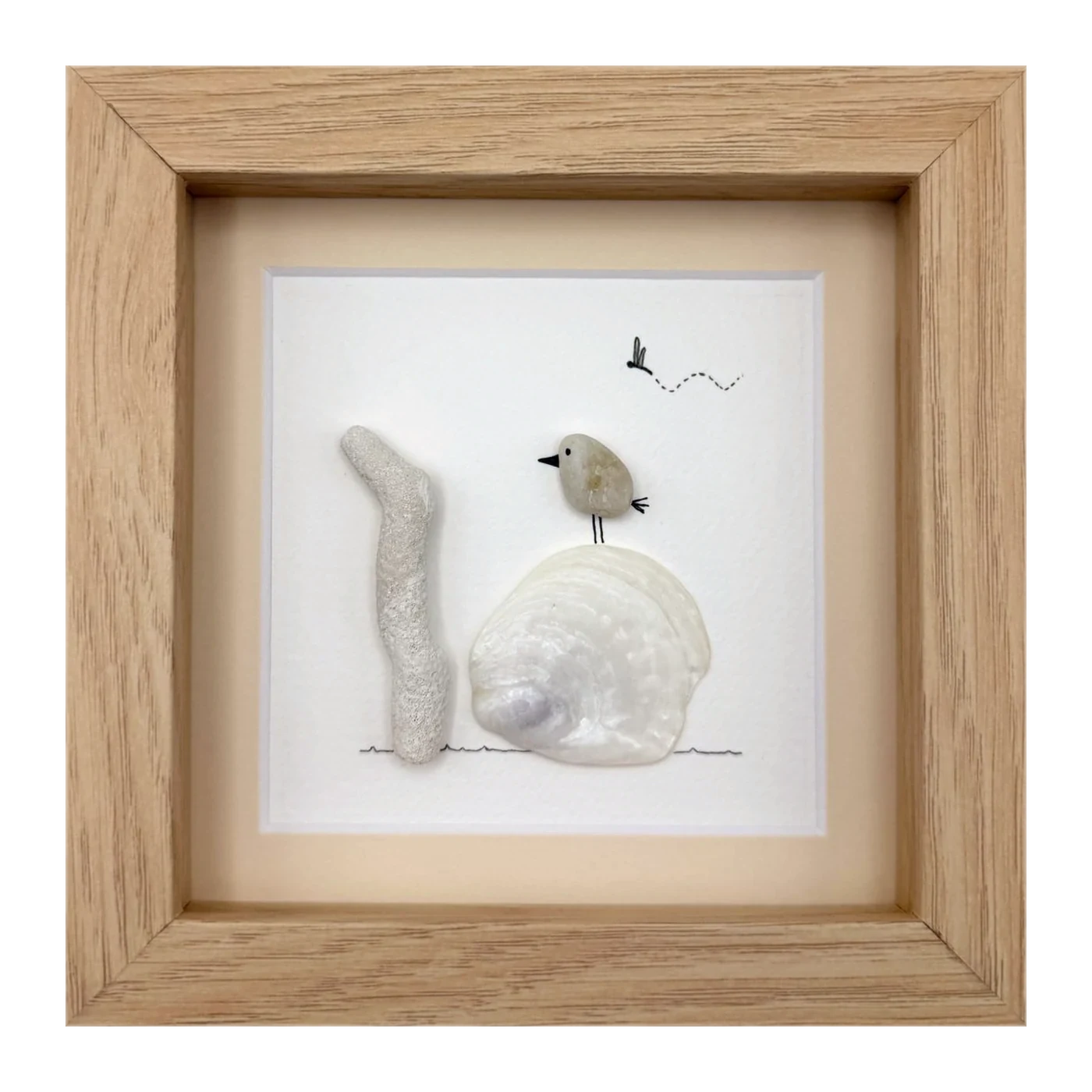A pebble bird on a white clam shell